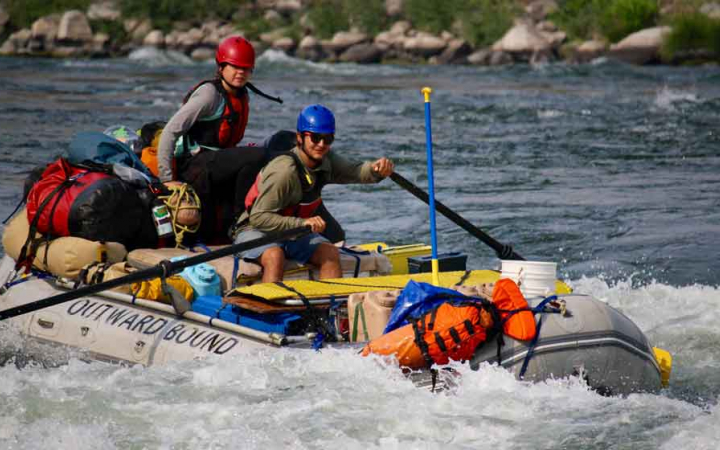 two people navigate whitewater in a raft 